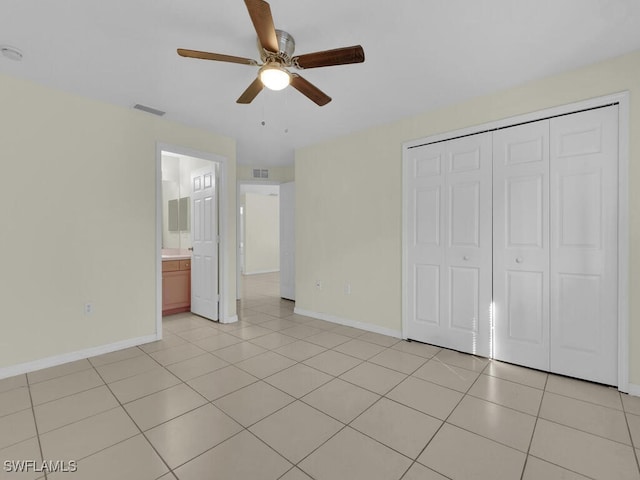 unfurnished bedroom featuring ceiling fan, a closet, and light tile patterned floors