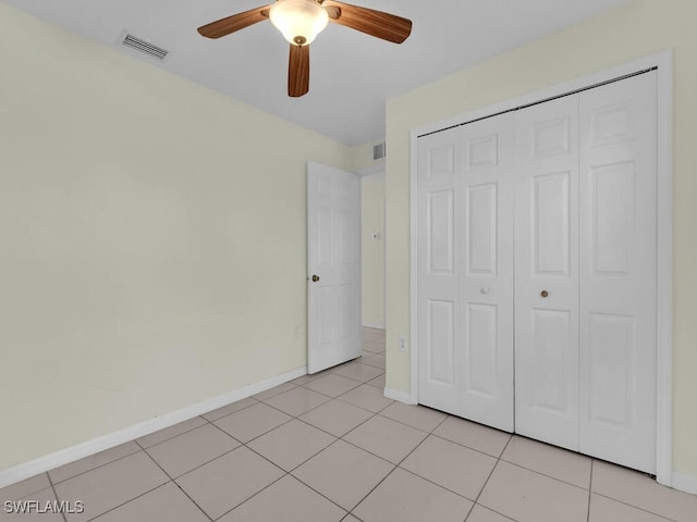 unfurnished bedroom featuring light tile patterned flooring, ceiling fan, and a closet