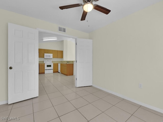 tiled spare room with ceiling fan and sink