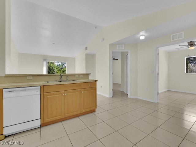 kitchen with vaulted ceiling, sink, light tile patterned flooring, and white dishwasher