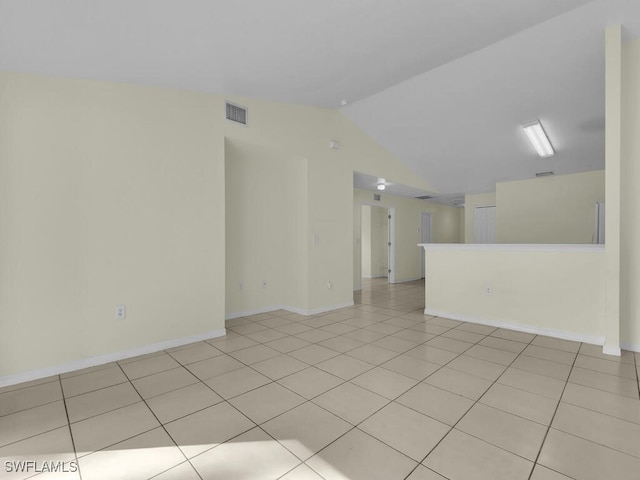 tiled empty room with lofted ceiling