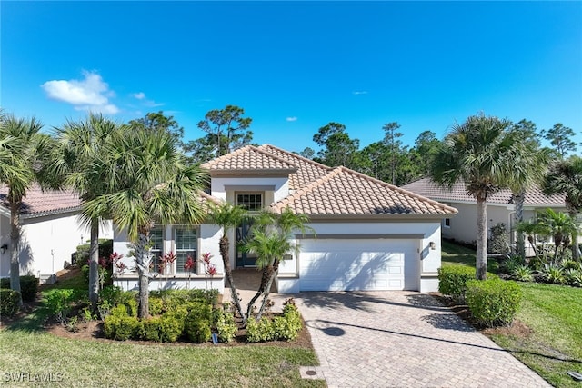 mediterranean / spanish-style home featuring a garage and a front lawn