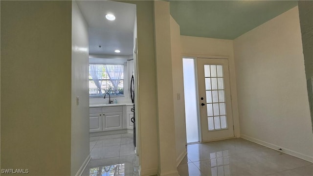 doorway to outside featuring sink and light tile patterned floors