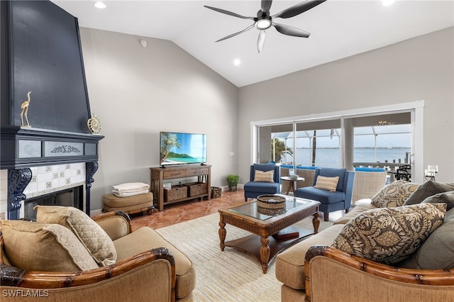 tiled living room with a tile fireplace, vaulted ceiling, and ceiling fan