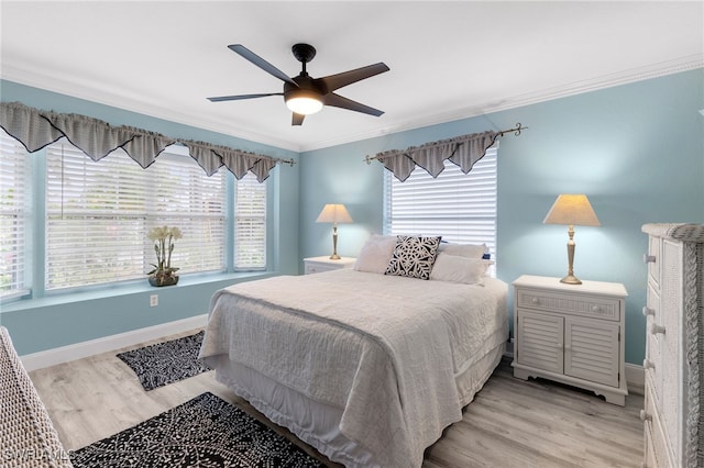 bedroom with crown molding, light hardwood / wood-style flooring, and ceiling fan