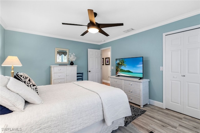 bedroom featuring light hardwood / wood-style flooring, ornamental molding, and a closet