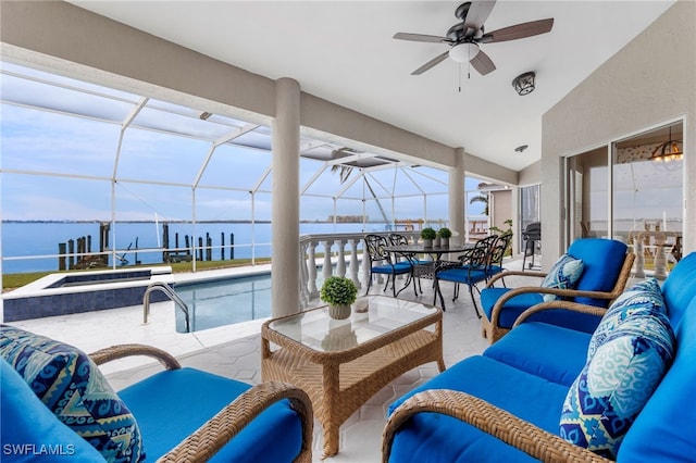 view of patio / terrace featuring a water view, ceiling fan, an outdoor hangout area, and glass enclosure