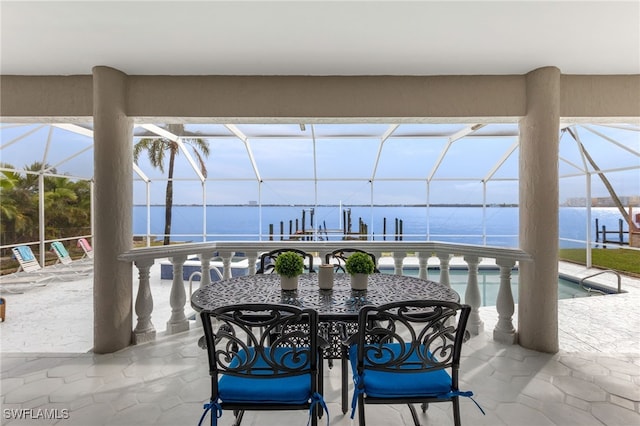 view of patio / terrace with a water view and a lanai