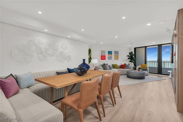 dining room with breakfast area, floor to ceiling windows, ceiling fan, and light wood-type flooring