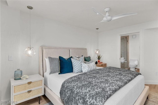 bedroom with connected bathroom and hardwood / wood-style floors