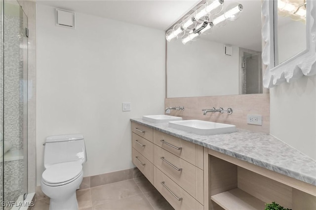 bathroom featuring decorative backsplash, tile patterned flooring, vanity, toilet, and a shower with door