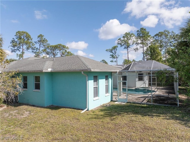 back of property with a lanai and a yard