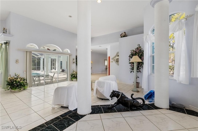 interior space featuring a towering ceiling and decorative columns