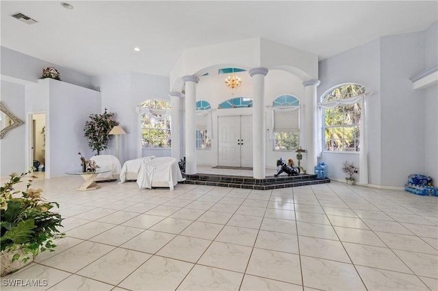 foyer featuring a chandelier and ornate columns