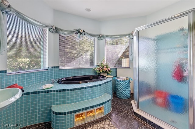 bathroom featuring plus walk in shower, tile patterned flooring, and tile walls