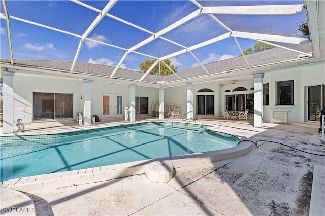 view of swimming pool featuring ceiling fan, glass enclosure, and a patio area