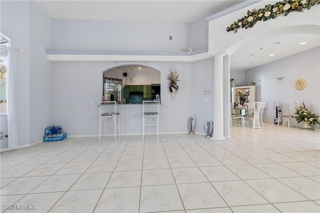 unfurnished living room with decorative columns