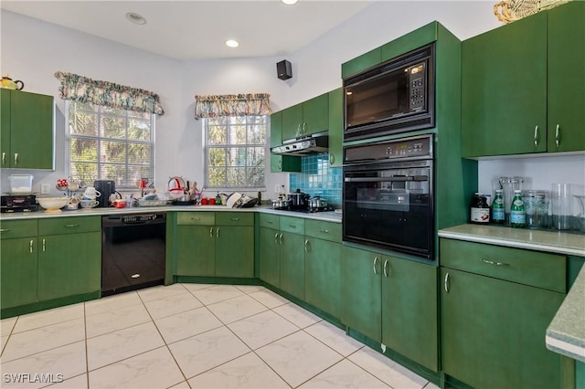 kitchen featuring tasteful backsplash, black appliances, and green cabinets