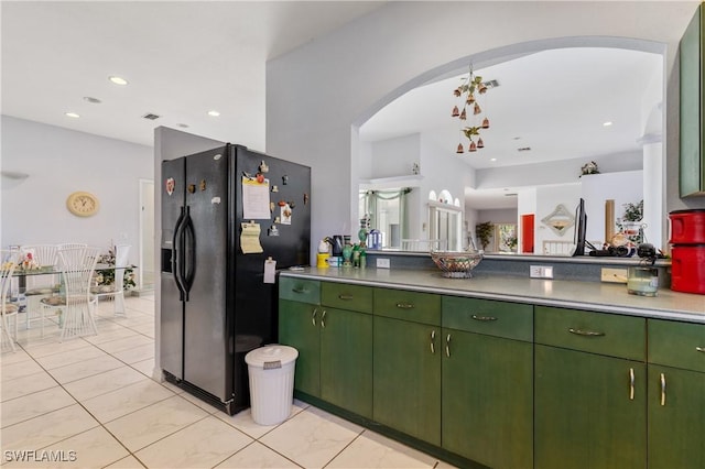 kitchen with green cabinetry and black fridge