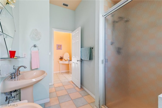 bathroom featuring tile patterned flooring and a shower with shower door