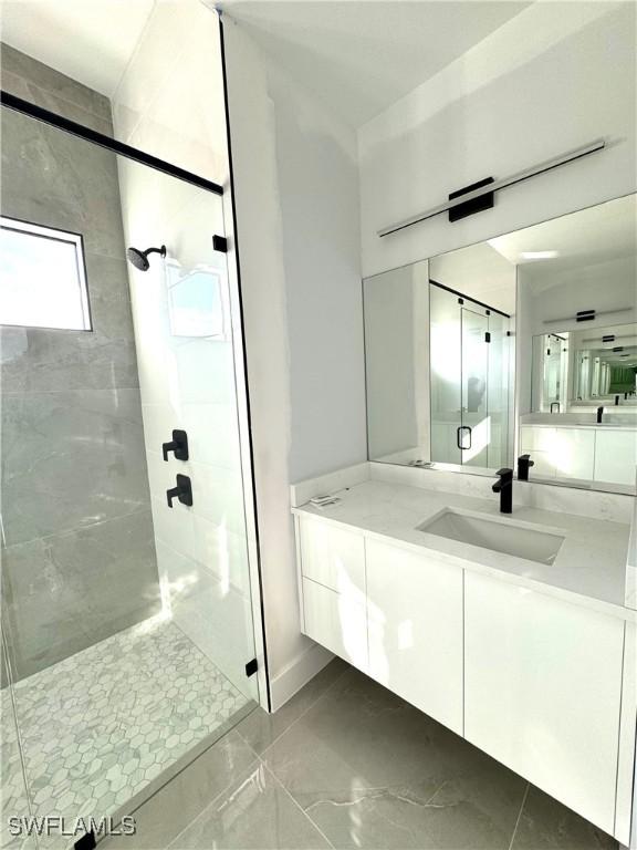 bathroom featuring vanity and a shower with door