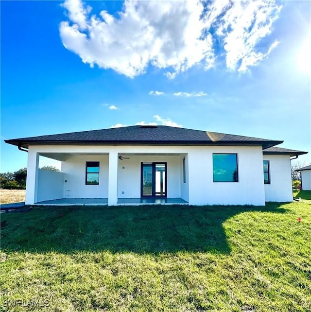 back of house featuring a patio area and a lawn