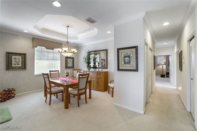 dining area with ornamental molding, light colored carpet, a notable chandelier, and a tray ceiling