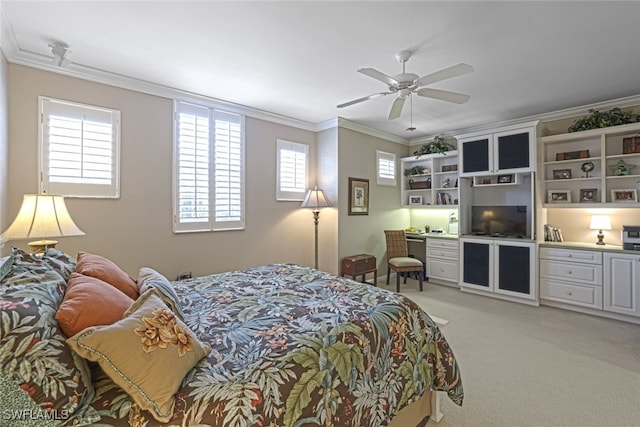 carpeted bedroom featuring multiple windows, crown molding, built in desk, and ceiling fan