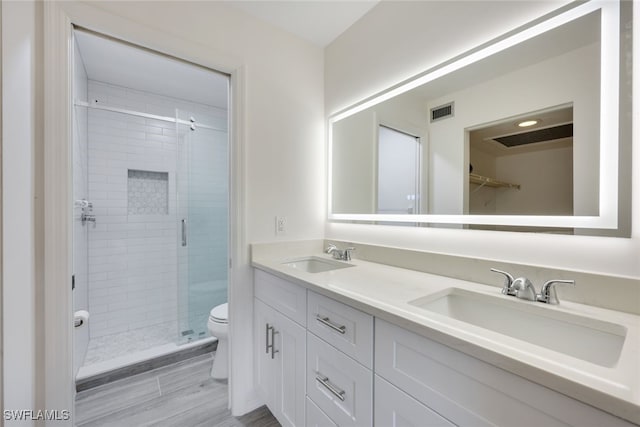 bathroom with double vanity, a stall shower, a sink, and visible vents