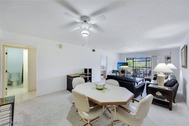 dining space featuring a ceiling fan, light colored carpet, visible vents, and light tile patterned floors