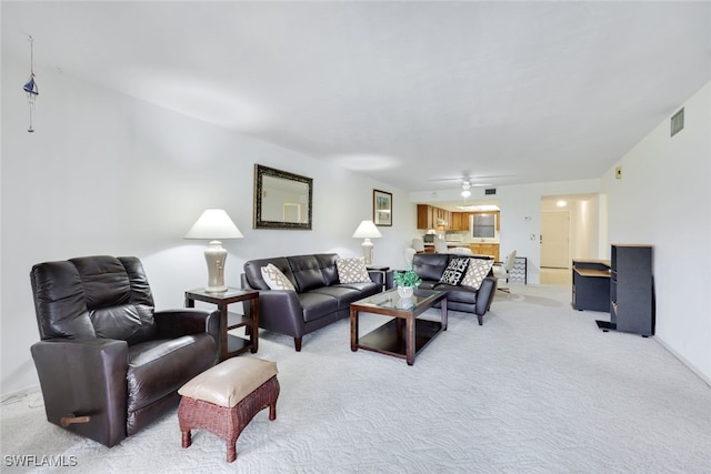 living area with light carpet, visible vents, and a ceiling fan