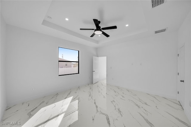 unfurnished room featuring ceiling fan and a tray ceiling