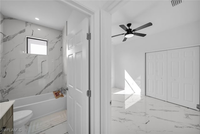 full bathroom with ceiling fan, vanity, toilet, and tiled shower / bath