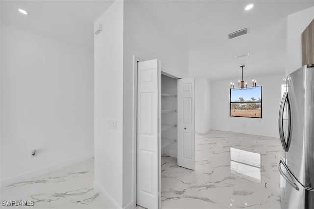 kitchen featuring a notable chandelier, decorative light fixtures, and stainless steel refrigerator