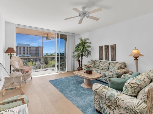 living room with expansive windows, ceiling fan, and wood-type flooring