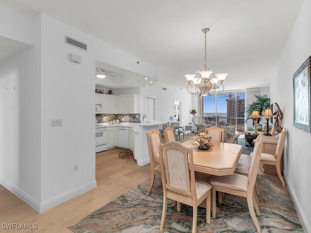 dining space with a chandelier and light wood-type flooring