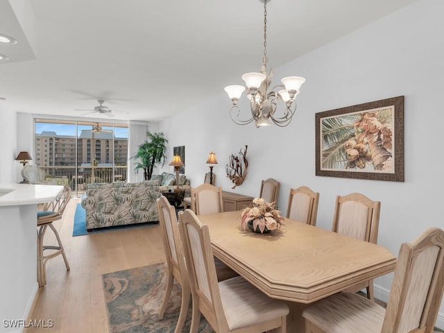 dining area featuring floor to ceiling windows, ceiling fan with notable chandelier, and light hardwood / wood-style flooring