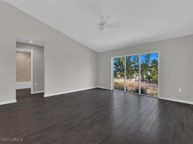 spare room with dark wood-type flooring, ceiling fan, and vaulted ceiling