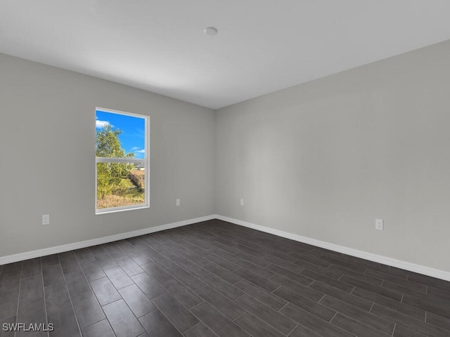 spare room with dark wood-type flooring