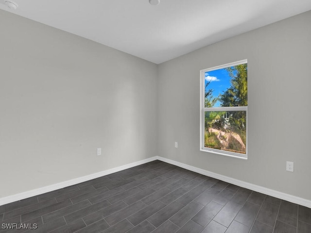 empty room with dark hardwood / wood-style flooring