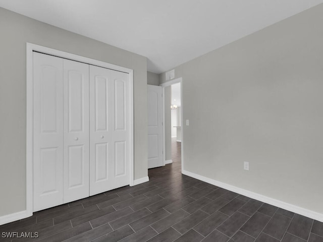 unfurnished bedroom featuring dark wood-type flooring and a closet