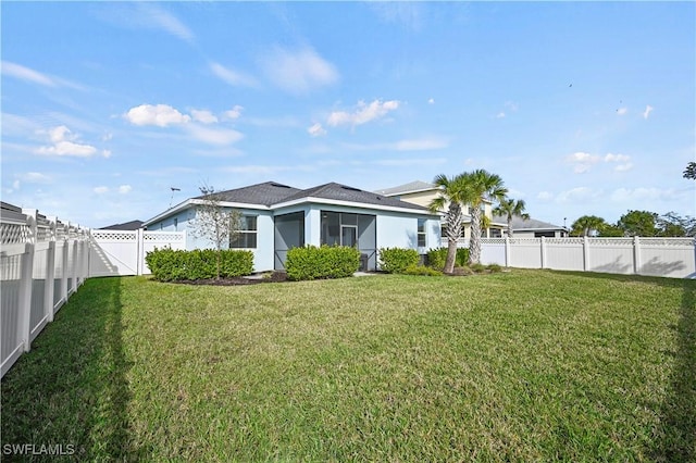 rear view of property with a lawn and a sunroom