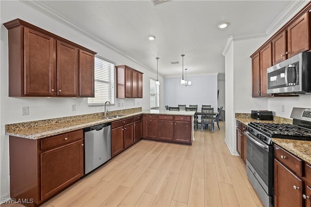 kitchen with sink, light hardwood / wood-style flooring, kitchen peninsula, pendant lighting, and stainless steel appliances