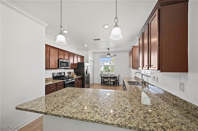 kitchen with visible vents, ornamental molding, appliances with stainless steel finishes, a peninsula, and a sink