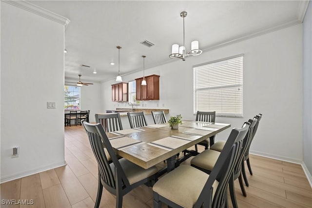 dining room featuring ornamental molding, sink, ceiling fan with notable chandelier, and light wood-type flooring