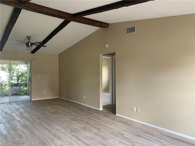 unfurnished room featuring ceiling fan, light hardwood / wood-style floors, a textured ceiling, and vaulted ceiling with beams