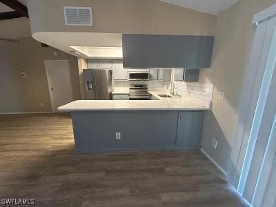 3926 Palm Tree Blvd, Cape Coral, FL 33904 - kitchen with appliances with stainless steel finishes, lofted ceiling, a peninsula, dark wood-style flooring, and light countertops