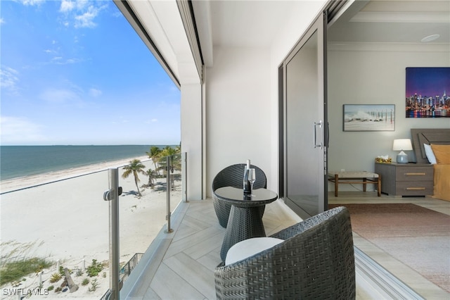 balcony featuring a beach view and a water view