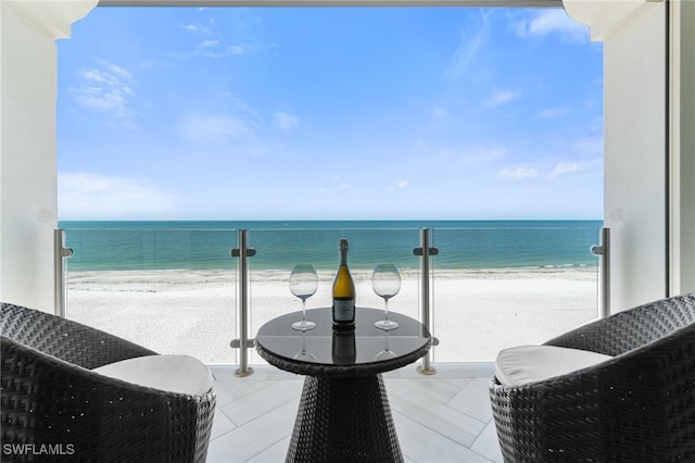 balcony with a water view and a view of the beach