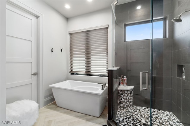 bathroom with recessed lighting, a shower stall, and a freestanding bath